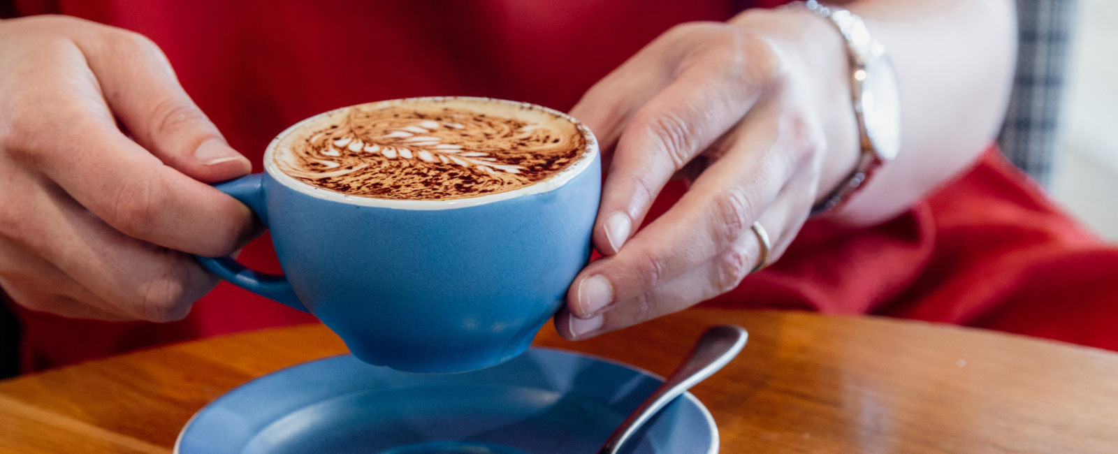 Person holding coffee at Coretto Cafe & Bar